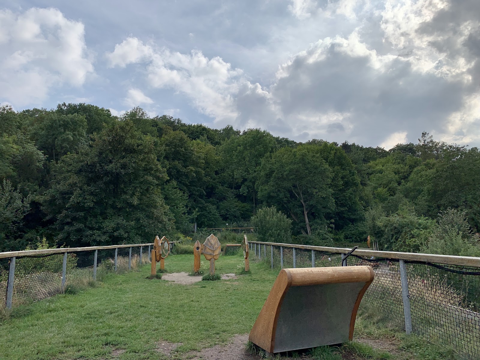 Lesní hřiště s interaktivními dřevěnými prvky, objevte přírodu.